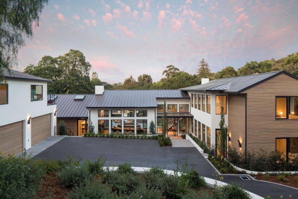 Representative modern Emerald Hills home with glass walls at dusk