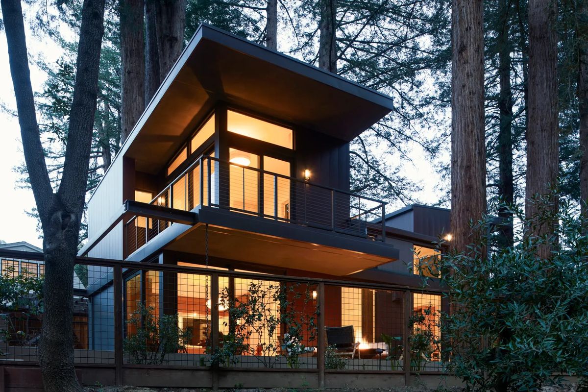 Modern home glowing at dusk among the redwoods